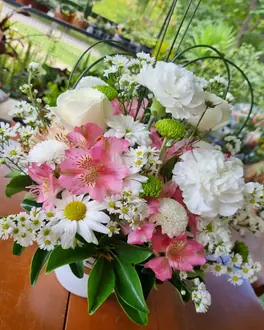 Arranjo de cravos brancos, alstroemérias rosa e margaridas em vaso